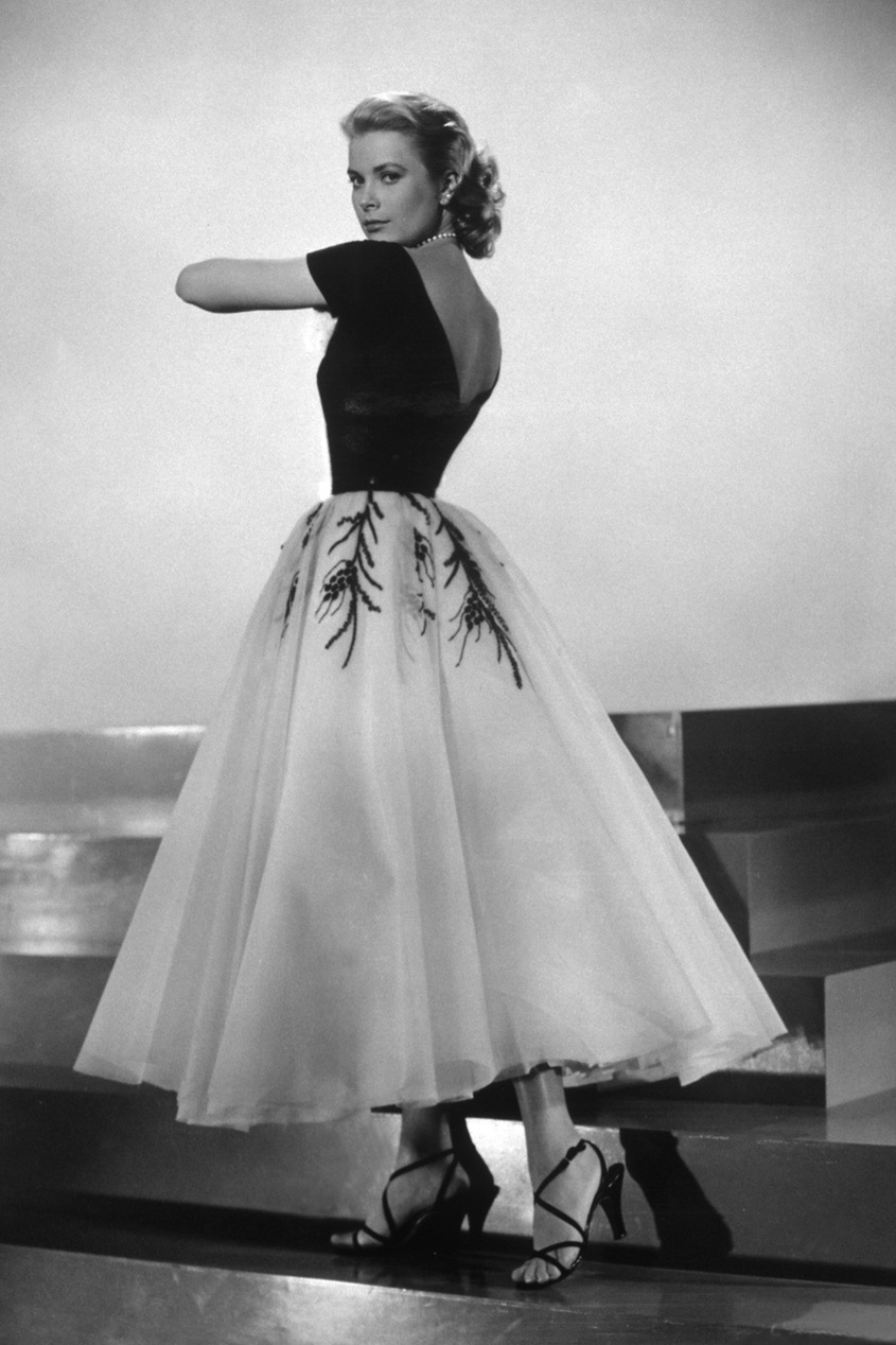 Een vrouw in een elegante zwart-witte baljurk in klassieke Hollywood-stijl, wat een sterk contrast vormt met de opkomst van sportmode.